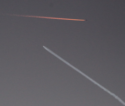 Falcon 9 ascending AND an airliner lit by the sunset